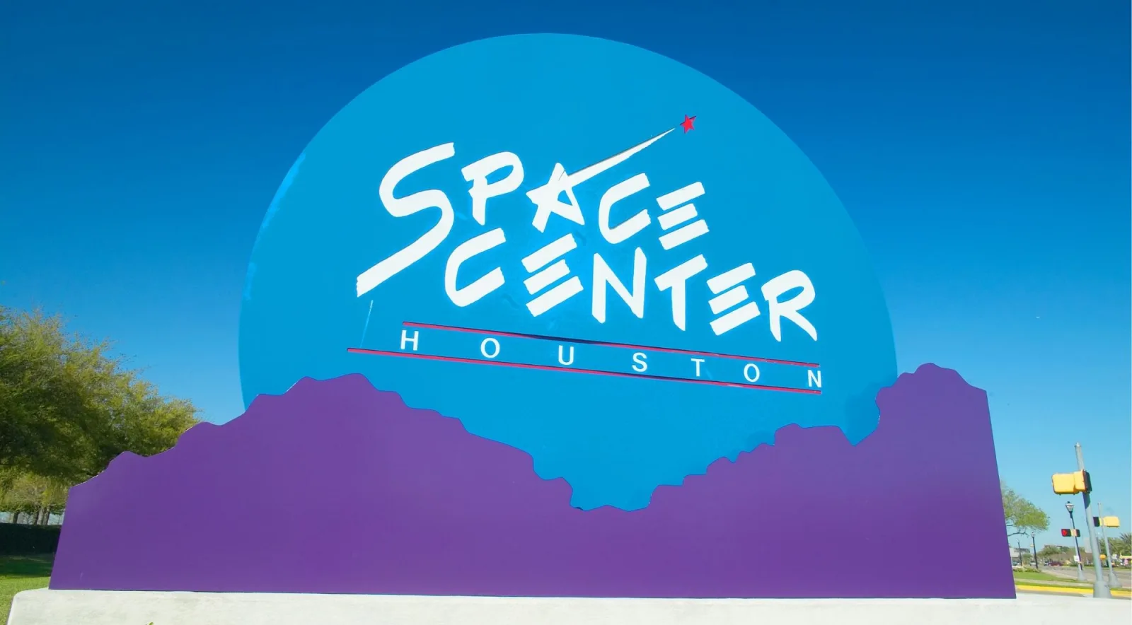 The colorful Space Center Houston entrance sign under a blue Texas sky