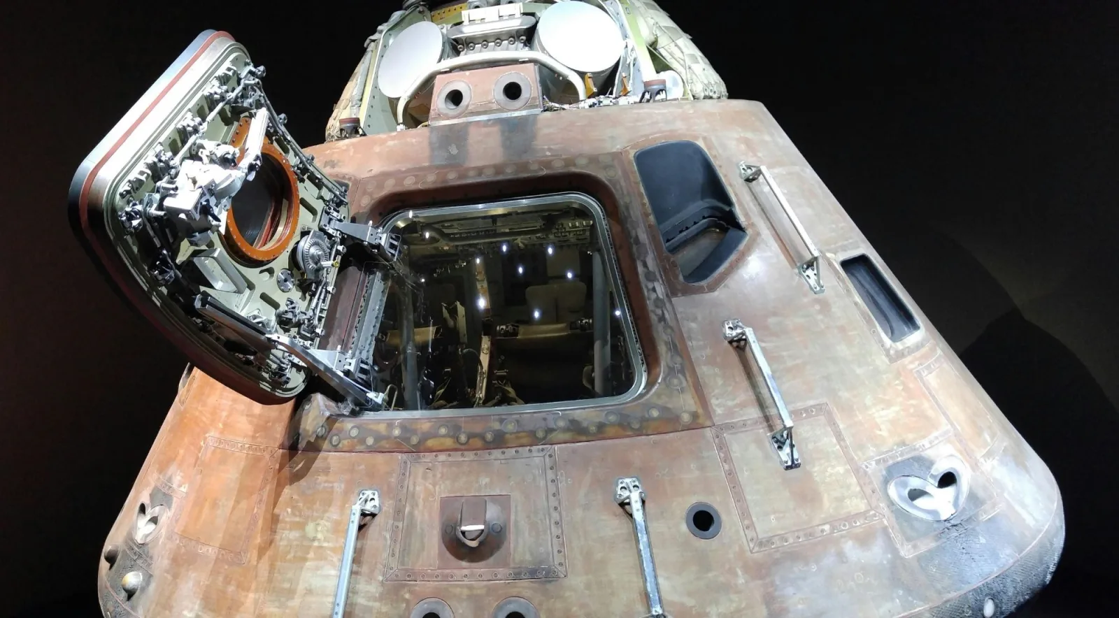 A heat-scorched Apollo command module with its hatch open