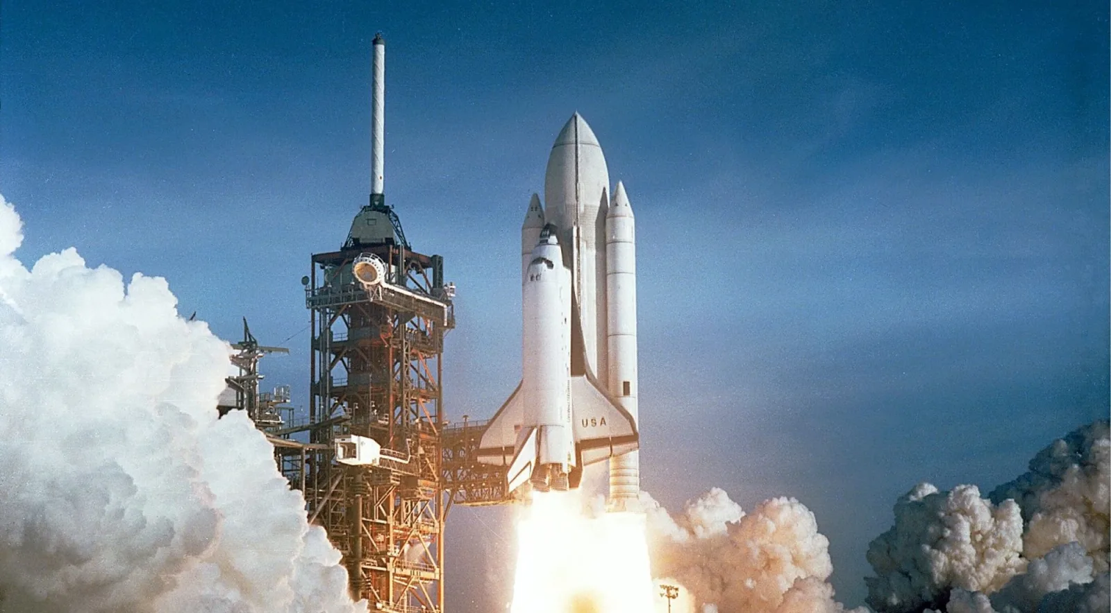 A NASA space shuttle lifting off in a cloud of smoke and flame
