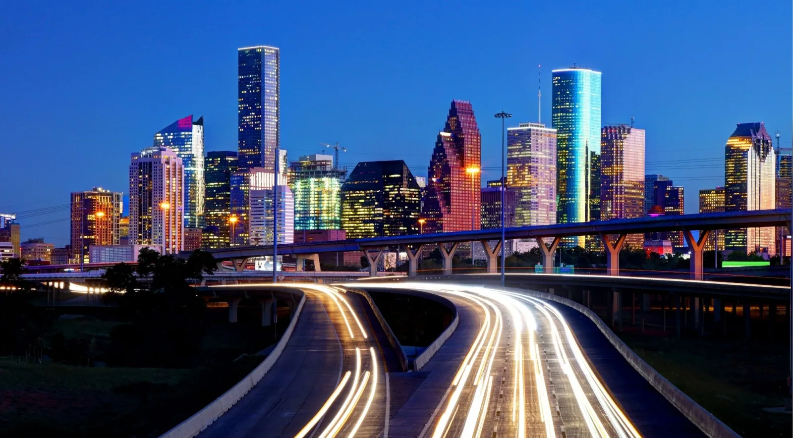 The Houston skyline at night with light trails on the highway
