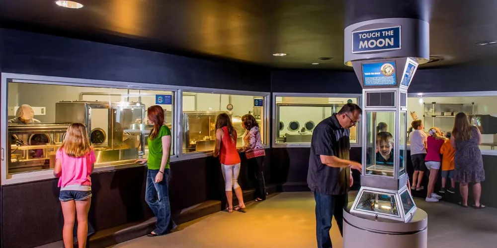 Visitors at the Touch the Moon lunar-sample exhibit at Space Center Houston