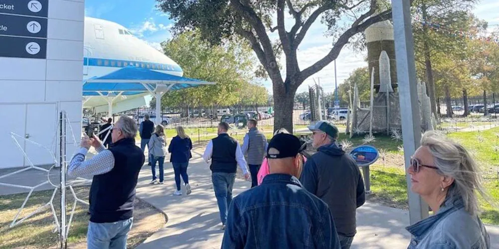 Guided group walking toward Independence Plaza and the shuttle carrier aircraft